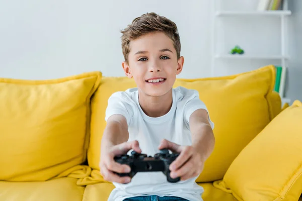 KYIV, UKRAINE - 2 OCTOBRE 2019 : mise au point sélective d'un enfant heureux jouant à un jeu vidéo à la maison — Photo de stock
