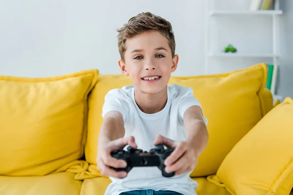 KYIV, UKRAINE - OCTOBER 2, 2019: selective focus of happy kid playing video game at home — Stock Photo