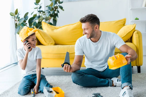 Pai feliz olhando para filho brincando com walkie talkie — Fotografia de Stock