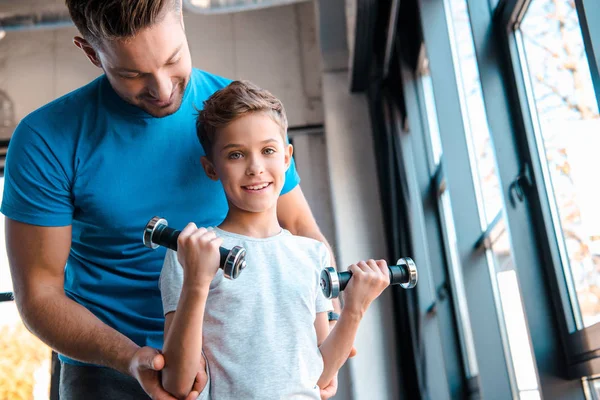 Heureux père regardant fils mignon avec haltères — Photo de stock