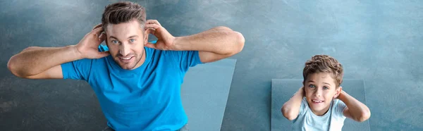 Panoramic shot of cute kid and father exercising on fitness mats — Stock Photo