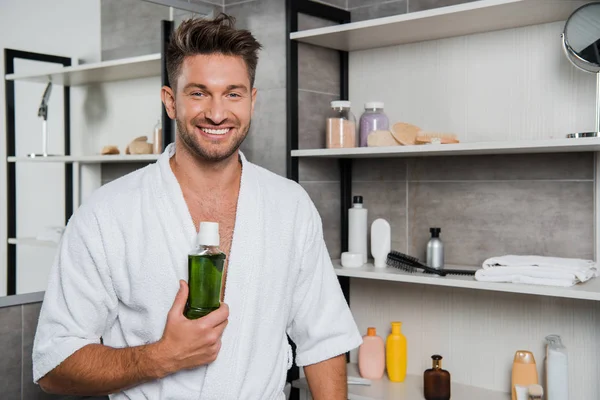 Щасливий чоловік тримає пляшку з зеленим посудом — стокове фото