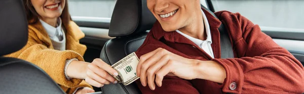 Vista ritagliata del passeggero che paga con conducente di taxi sorridente, colpo panoramico — Foto stock