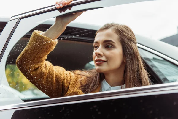 Junge Frau blickt durch Fenster der Autotür — Stockfoto