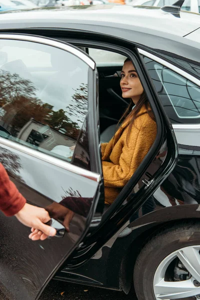 Passeggero donna sorridente mentre tassista apertura porta auto — Foto stock