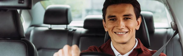 Imagen panorámica del hombre sonriente conduciendo el coche - foto de stock