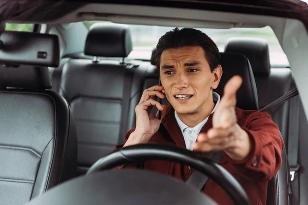 Homem perturbado falando no smartphone enquanto dirige o carro — Fotografia de Stock