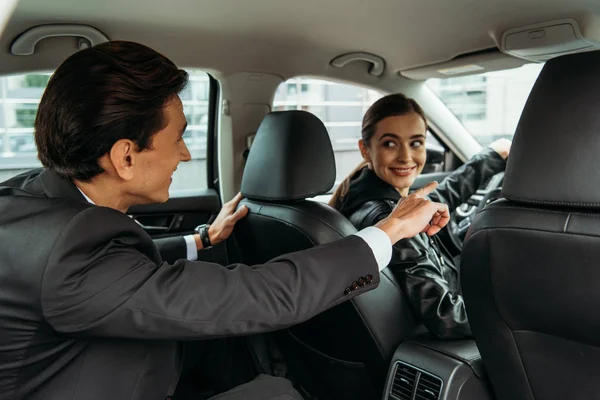 Businessman pointing on road to smiling taxi driver — Stock Photo
