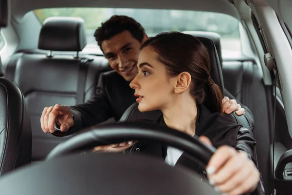 Empresário apontando na estrada para motorista de táxi feminino no carro — Fotografia de Stock