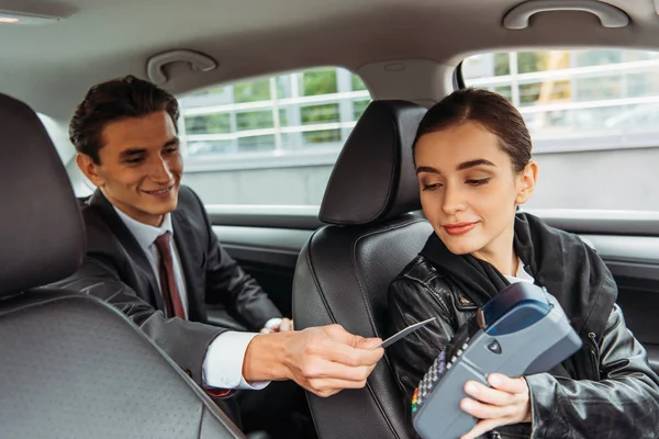 Empresario pagando con tarjeta de crédito en taxi - foto de stock