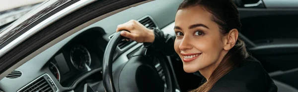 Tiro panorâmico de motorista de táxi feminino segurando volante — Fotografia de Stock