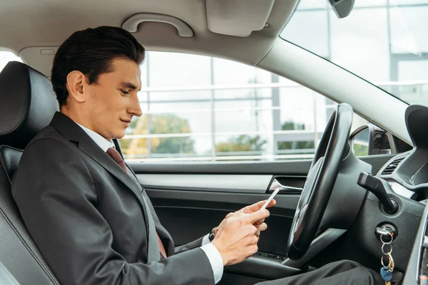 Vista laterale di uomo d'affari utilizzando smartphone in drone auto — Foto stock