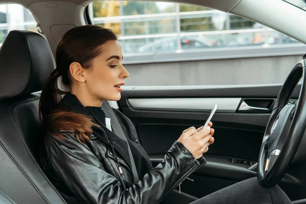 Young woman using smartphone on driver seat of drone car — Stock Photo