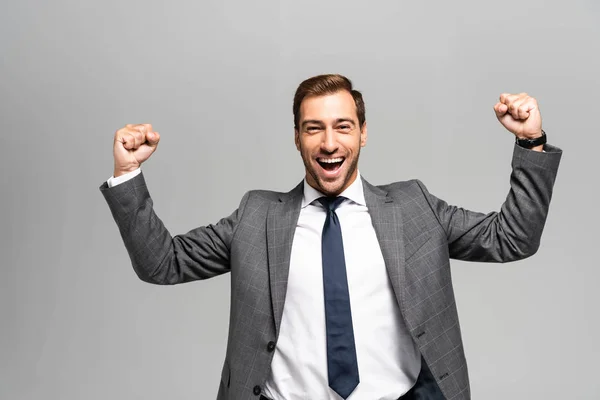 Gutaussehender und lächelnder Geschäftsmann im Anzug zeigt Ja-Geste isoliert auf grau — Stockfoto