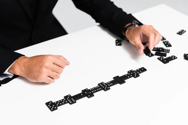 Cropped view of businessman in suit playing domino — Stock Photo