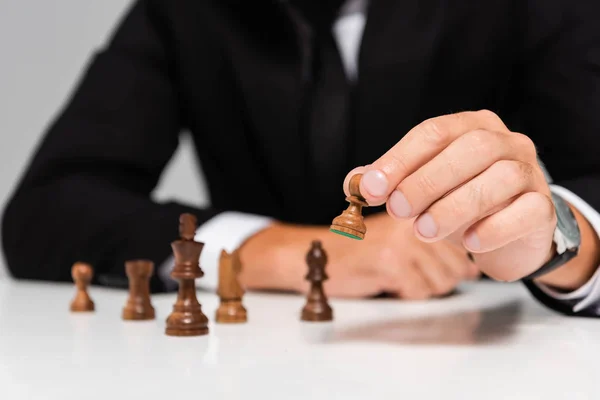 Cropped view of businessman in black suit playing chess — Stock Photo