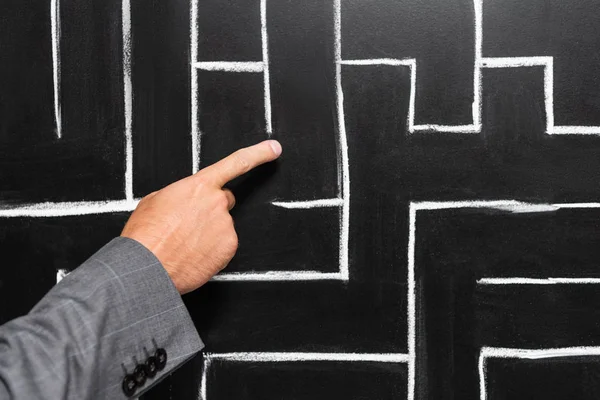 Cropped view of businessman in suit pointing with finger at labyrinth — Stock Photo