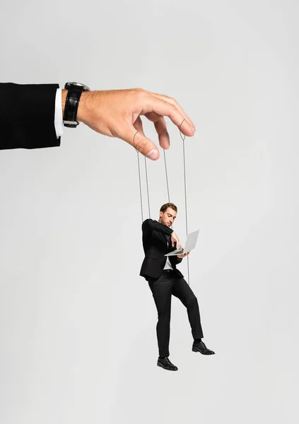 Cropped view of businessman playing with marionette with laptop isolated on grey — Stock Photo