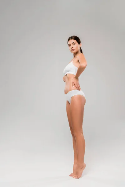 In voller Länge Ansicht der schönen schlanken Frau in Unterwäsche posiert auf Zehenspitzen auf grau — Stockfoto