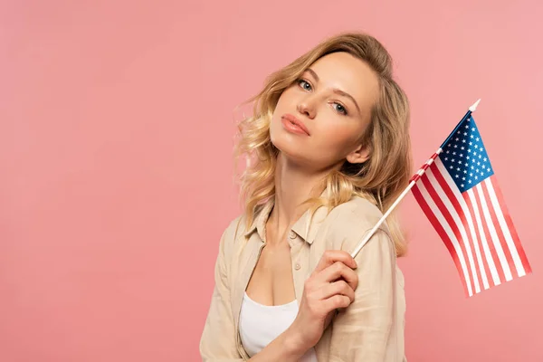 Attraktive Frau mit amerikanischer Flagge in der Hand isoliert auf rosa — Stockfoto