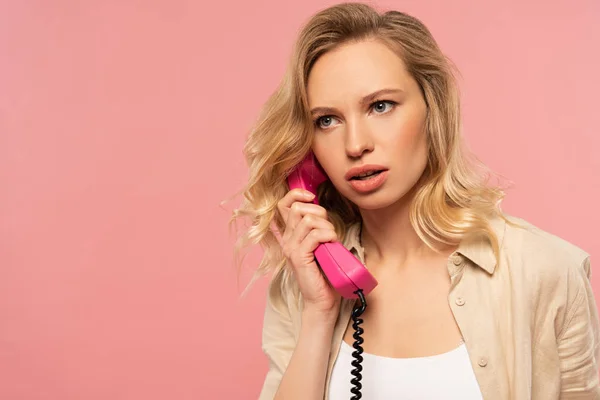 Mulher loira séria falando no telefone retro isolado no rosa — Fotografia de Stock