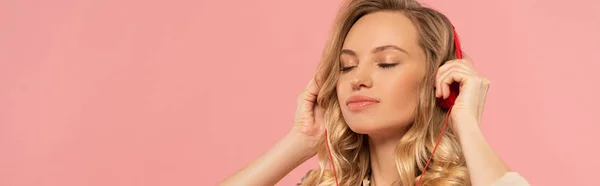 Blonde woman with closed eyes in headphone isolated on pink, panoramic shot — Stock Photo