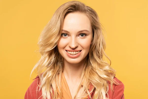 Портрет улыбающейся блондинки, изолированной на желтом — стоковое фото