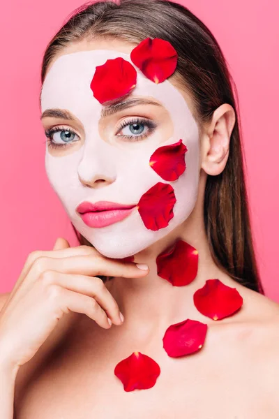 Гола красива жінка в масці для обличчя з пелюстками троянд ізольована на рожевому — стокове фото