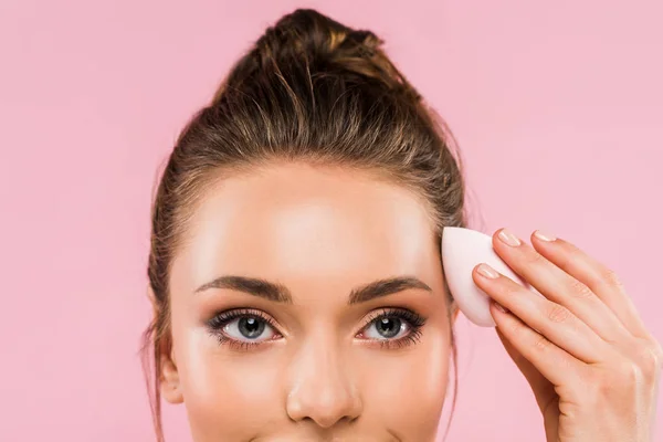 Vista recortada de la hermosa mujer sosteniendo esponja de maquillaje aislado en rosa - foto de stock