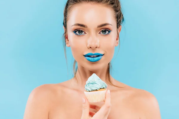 Гола красива жінка з блакитними губами і кексом ізольована на синьому — стокове фото