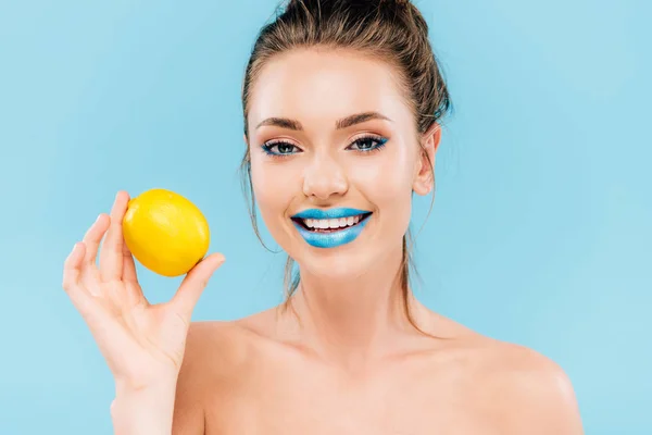 Glücklich nackte schöne Frau mit blauen Lippen hält ganze Orange isoliert auf blau — Stockfoto