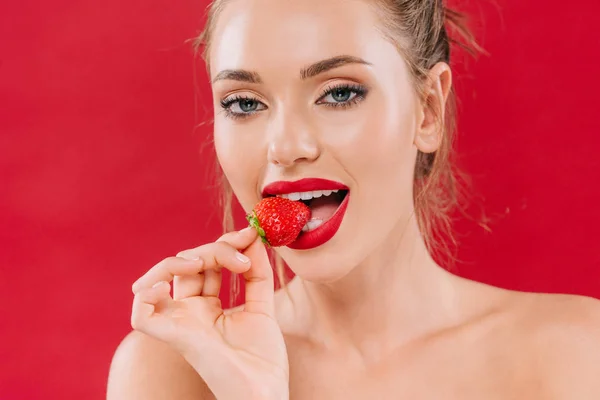 Гола красива жінка з червоними губами їсть полуницю ізольовано на червоному — Stock Photo