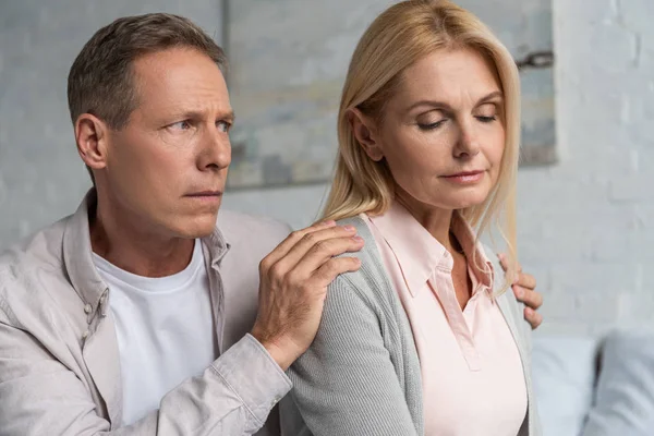 Man calming down worried wife at home — Stock Photo