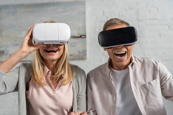 Pareja sonriente en realidad virtual auriculares en casa - foto de stock