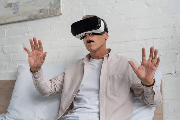 Aufgebrachter Mann in Virtual-Reality-Headset auf Bett — Stockfoto