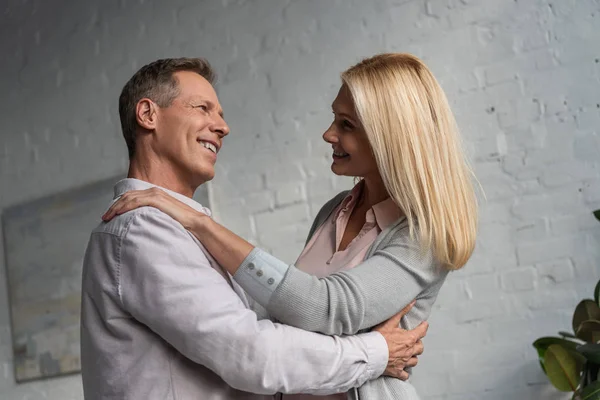 Smiling mature couple dancing in living room — Stock Photo