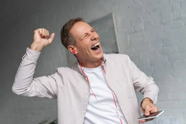 Hombre salido en auriculares bailando en la sala de estar - foto de stock