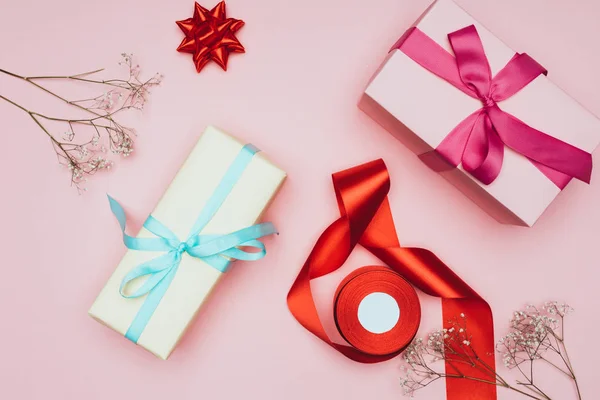 Top view of christmas gift boxes with flowers, ribbons and bows, isolated on pink — Stock Photo