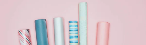 Panoramic shot of wrapping paper rolls on pink — Stock Photo