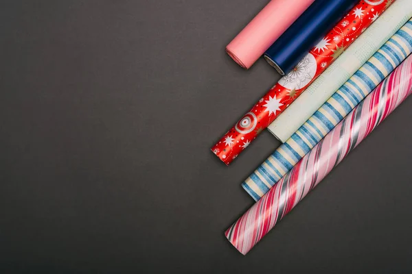 Top view of wrapping paper rolls on black — Stock Photo