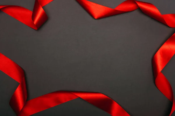 Top view of christmas red ribbon on black — Stock Photo