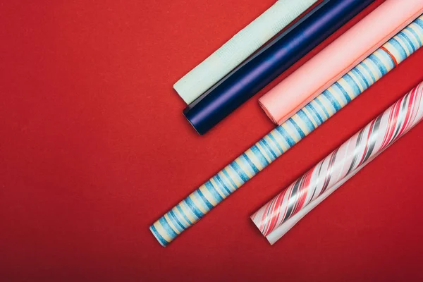 Top view of wrapping paper rolls on red — Stock Photo