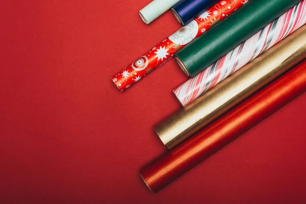 Top view of wrapping paper rolls on red — Stock Photo