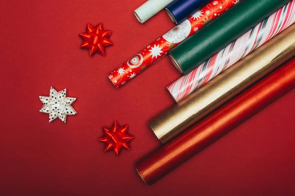 Vue du dessus des rouleaux et arcs de papier d'emballage sur rouge — Photo de stock