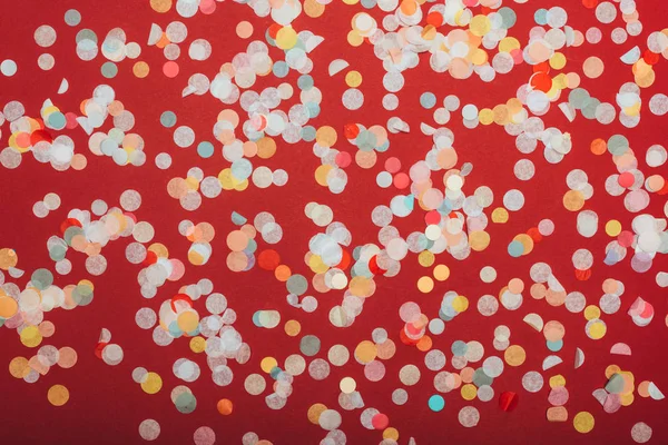 Top view of christmas confetti on red — Stock Photo