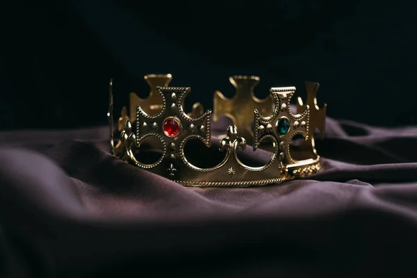 Retro golden crown with gemstones on black cloth — Stock Photo