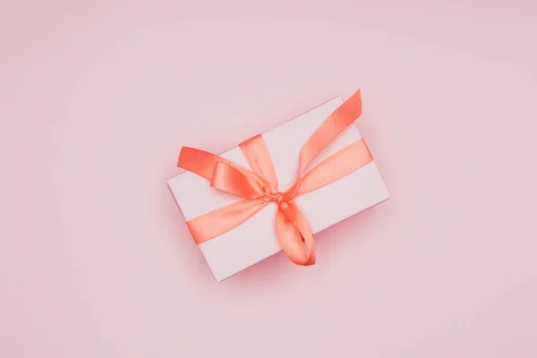 Top view of traditional christmas gift with ribbon, isolated on pink — Stock Photo