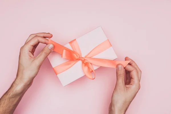 Cropped view of man packing christmas gift box, isolated on pink — Stock Photo