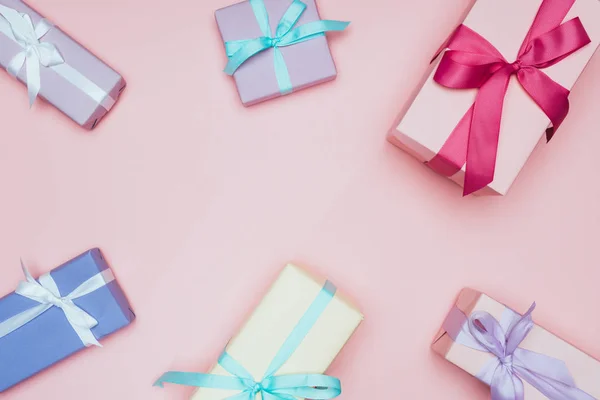 Vista superior de las cajas de regalo de Navidad con arcos, aisladas en rosa - foto de stock