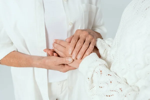 Vista ritagliata di madre e figlia tenendo le mani isolate su grigio — Foto stock